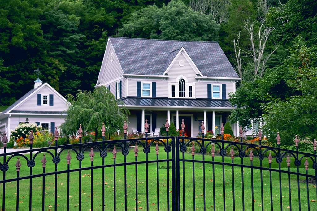 Custom designer shingle and metal roof installation on a blue-gray home and outbuilding in Cincinnati, Ohio.