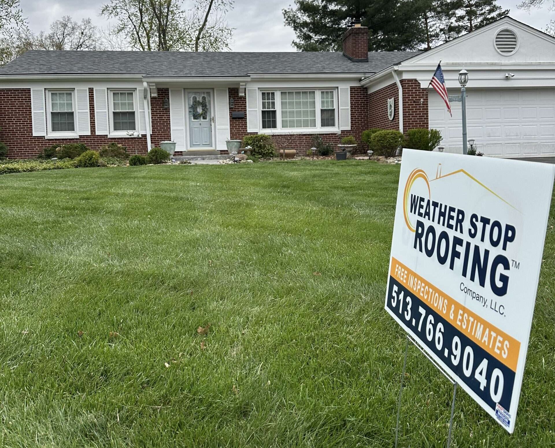 An Estate Gray Shingle Roof Replacement On A Brick Ranch In Cincinnati, OH with a Weather Stop Roofing Yard Sign in Foreground of Front Lawn