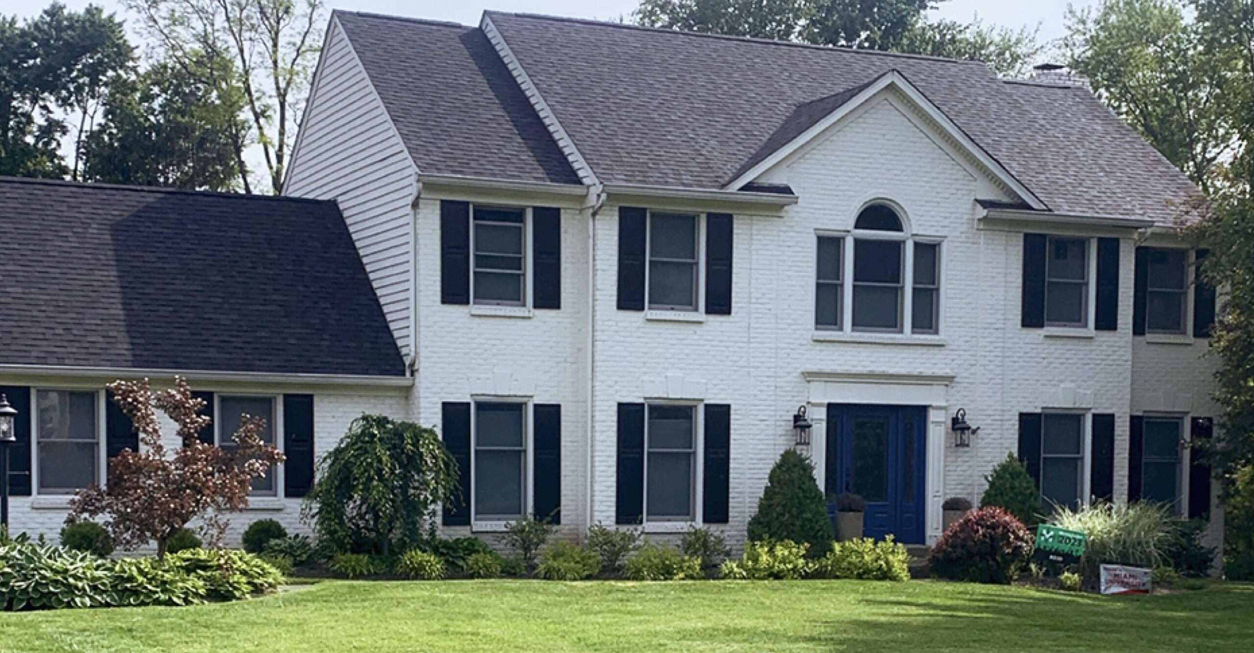 A bold, high-contrast shingle roof replacement by Weather Stop Roofing on a white brick two-story home in Greater Cincinnati.