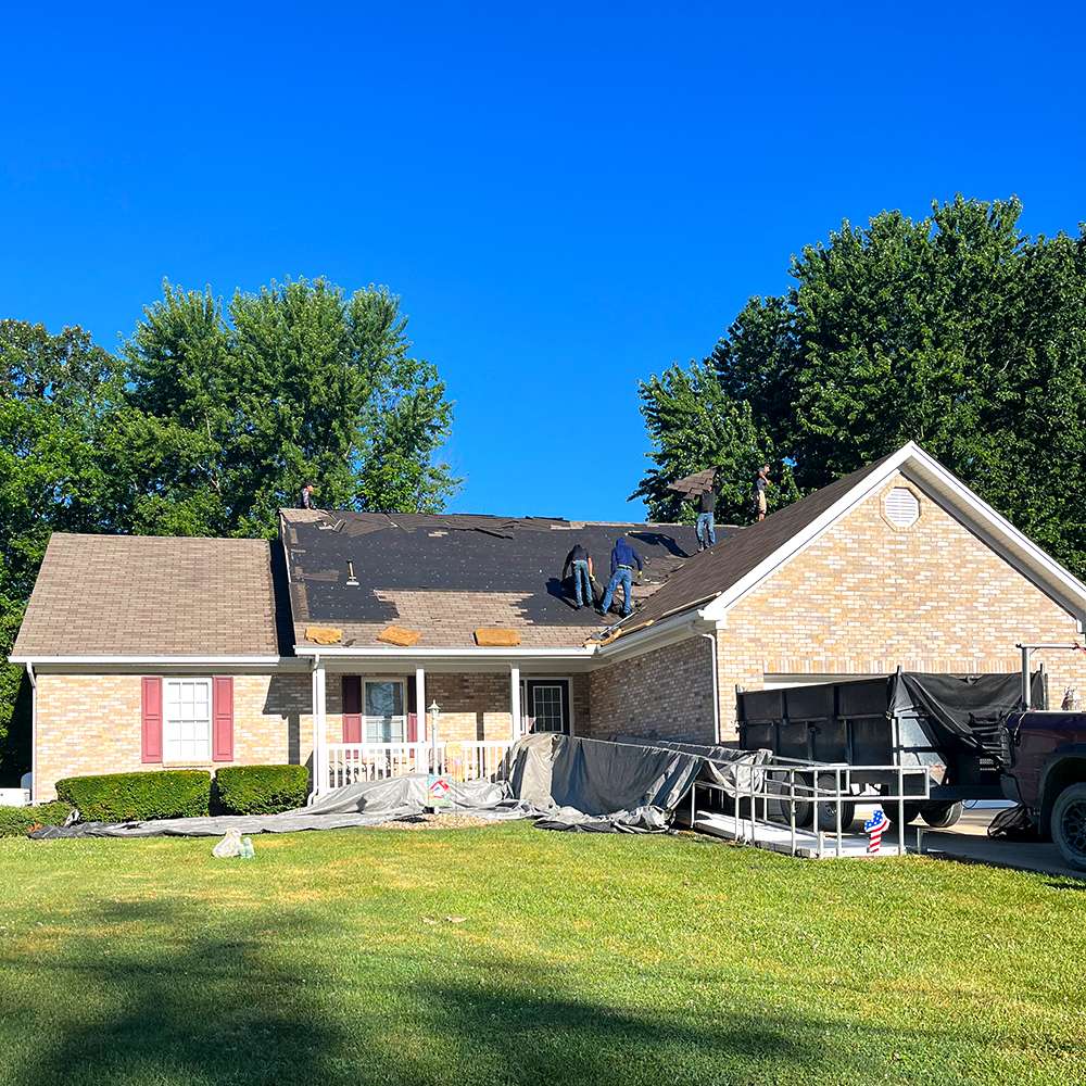 Weather Stop Roofing team using protective tarps on a deck during a professional roof replacement in Greater Cincinnati, OH.